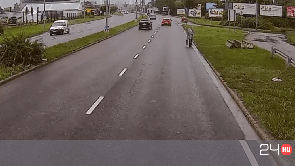 Videón, ahogy egy idős nő sétál az M5 bevezető szakaszán