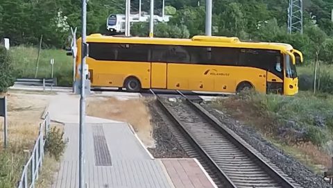 Videón, ahogy a piroson áthajtó, sorompót letörő buszsofőr átcsusszan az érkező vonat előtt