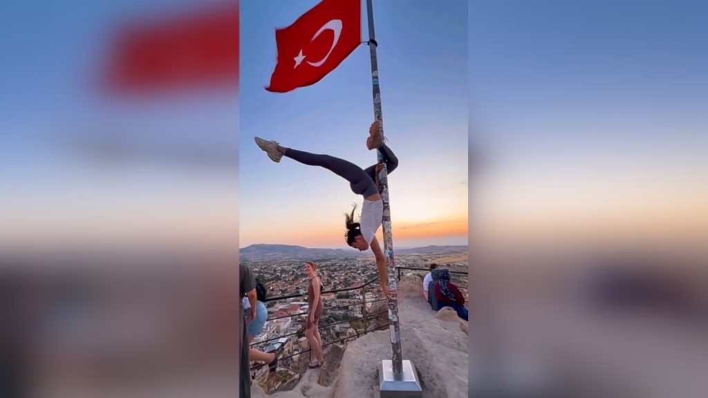 Börtönnel fenyegetnek egy fiatal nőt, mert rúdtáncos mutatványt hajtott végre egy zászlórúdon, Törökországban