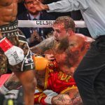 Christopher Young bíró számol az amerikai bokszoló és influencer Jake Paul felett, aki a padlón ül a brit bokszoló Anthony Joshua (balra) elleni, nem címért folyó nehézsúlyú mérkőzésen a floridai Miami Kaseya Centerben.