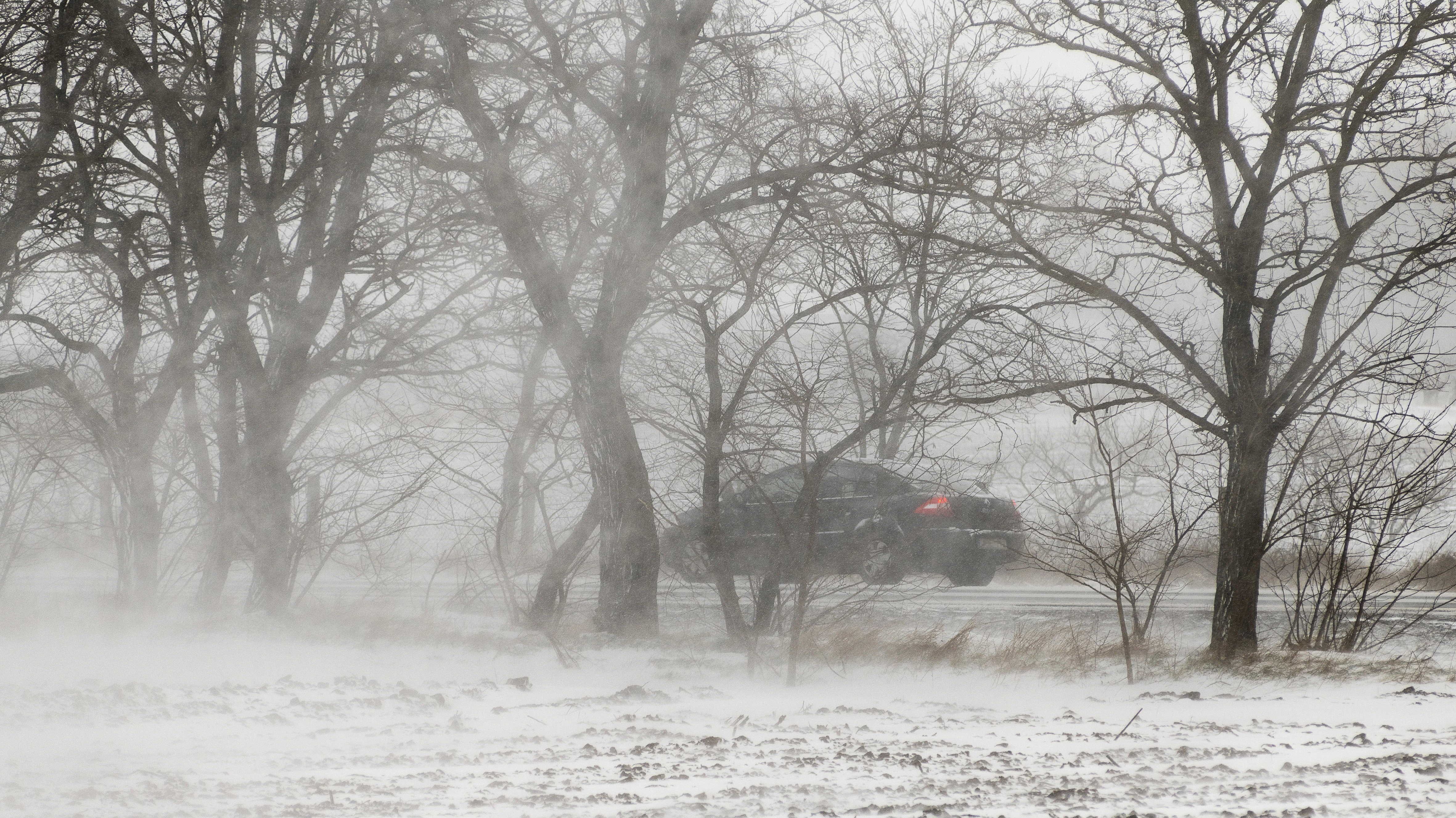 autó téli tájban, hófúvás közben