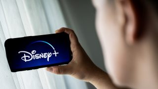 Egy férfi Disney+-t néz a telefonján