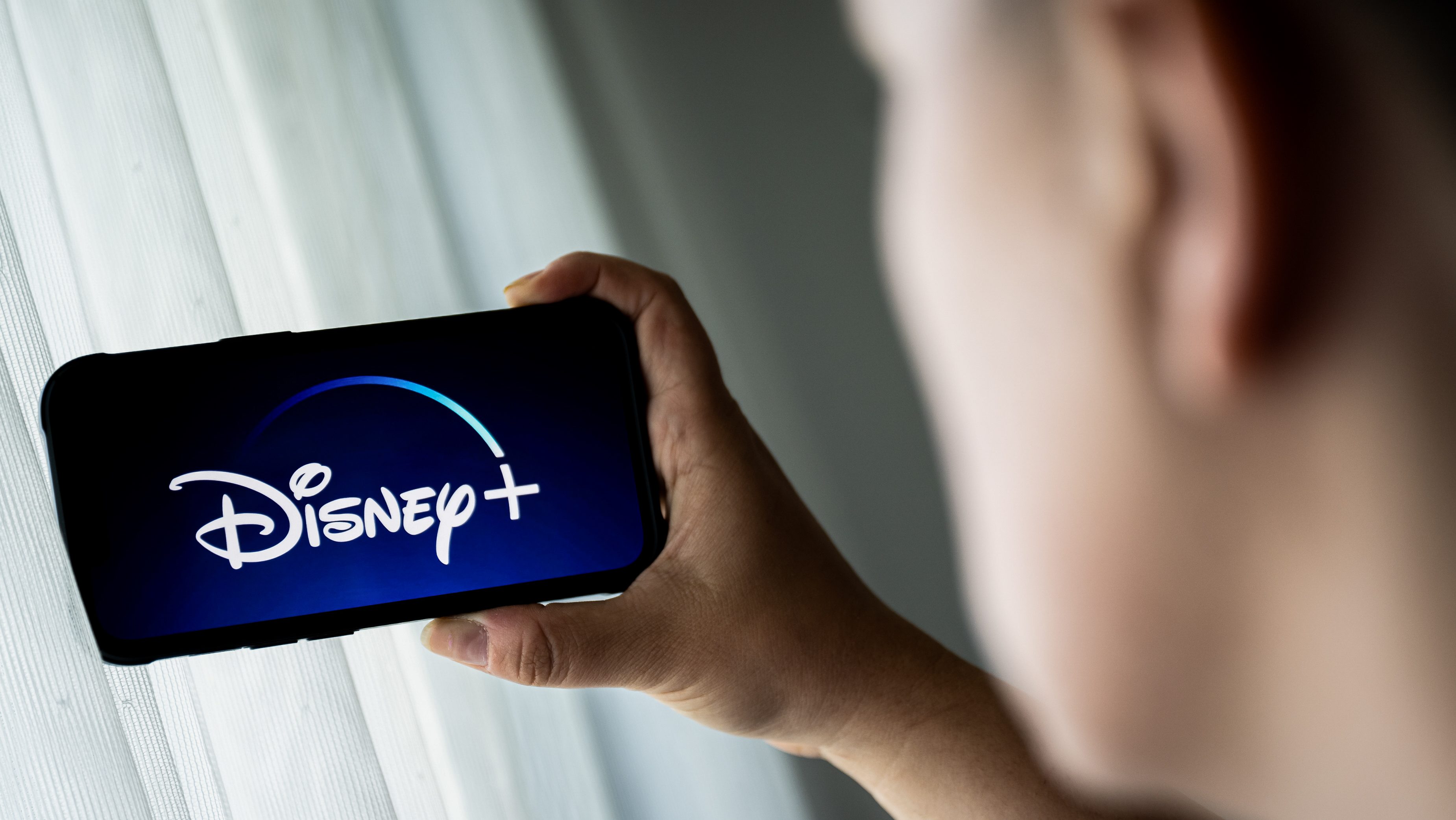 Egy férfi Disney+-t néz a telefonján