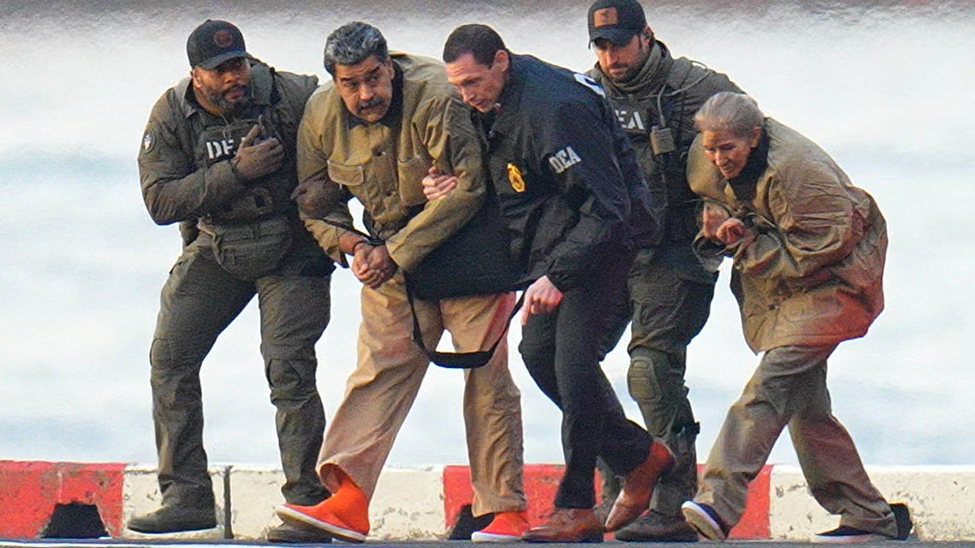 Nicolas Maduro és felesége, Cilia Flores, bilincsben láthatók, miután leszálltak egy manhattani helikopterleszállón, és nehézfegyverzetű szövetségi ügynökök kíséretében egy páncélozott autóba szállnak, hogy eljussanak a manhattani szövetségi bíróságra 2026. január 5-én New York Cityben.