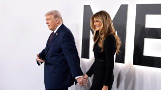 Donald Trump és Melania Trump kézenfogva sétálnak a Trump Kennedy Center vörös szőnyegén