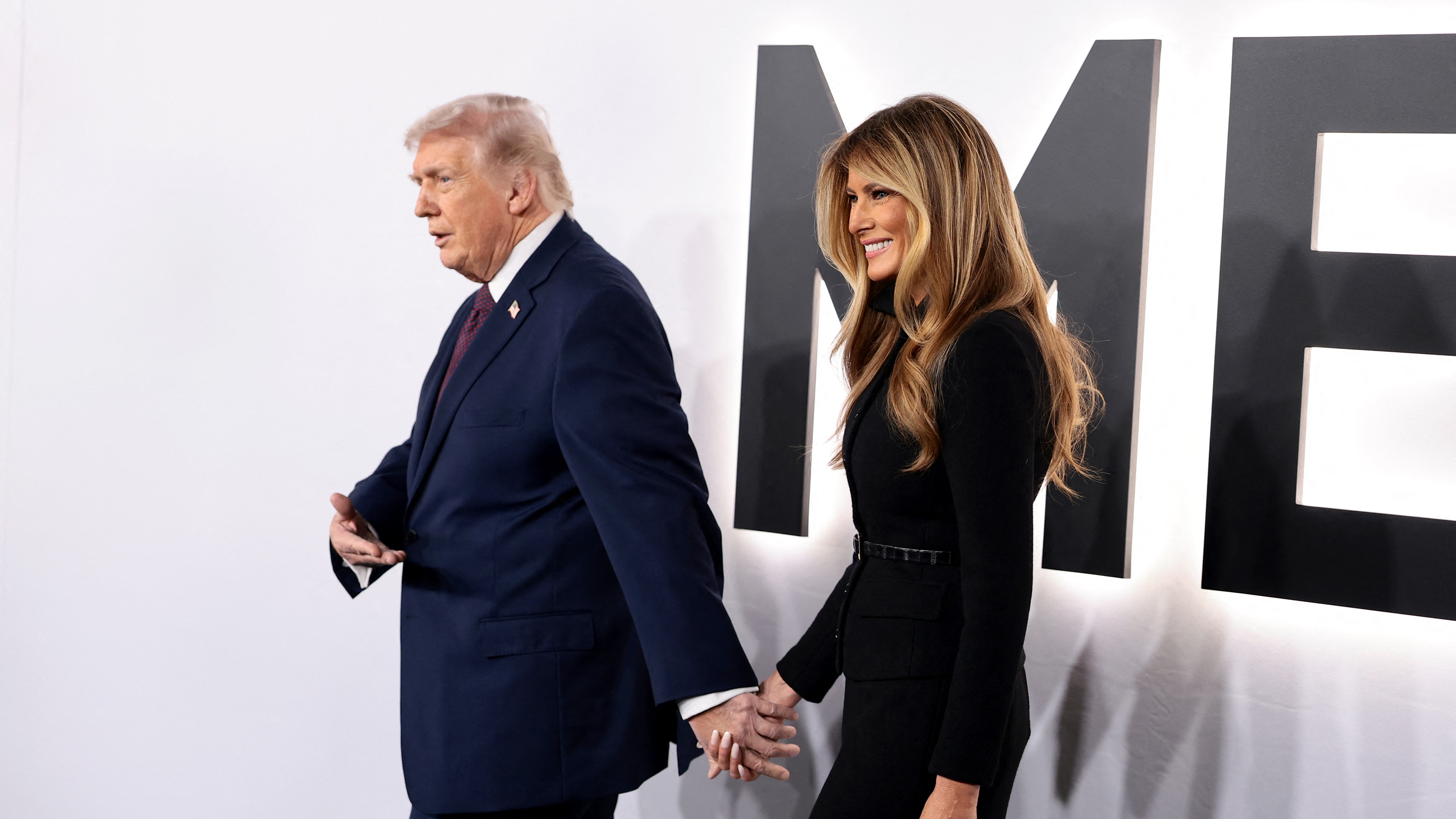 Donald Trump és Melania Trump kézenfogva sétálnak a Trump Kennedy Center vörös szőnyegén