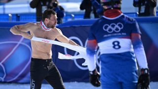 Austria's Benjamin Karl removes his jersey as he celebrates his victory in the snowboard men's parallel giant slalom final at Livigno Snow Park during the Milano Cortina 2026 Winter Olympic Games, in Livigno (Valtellina), on February 8, 2026.