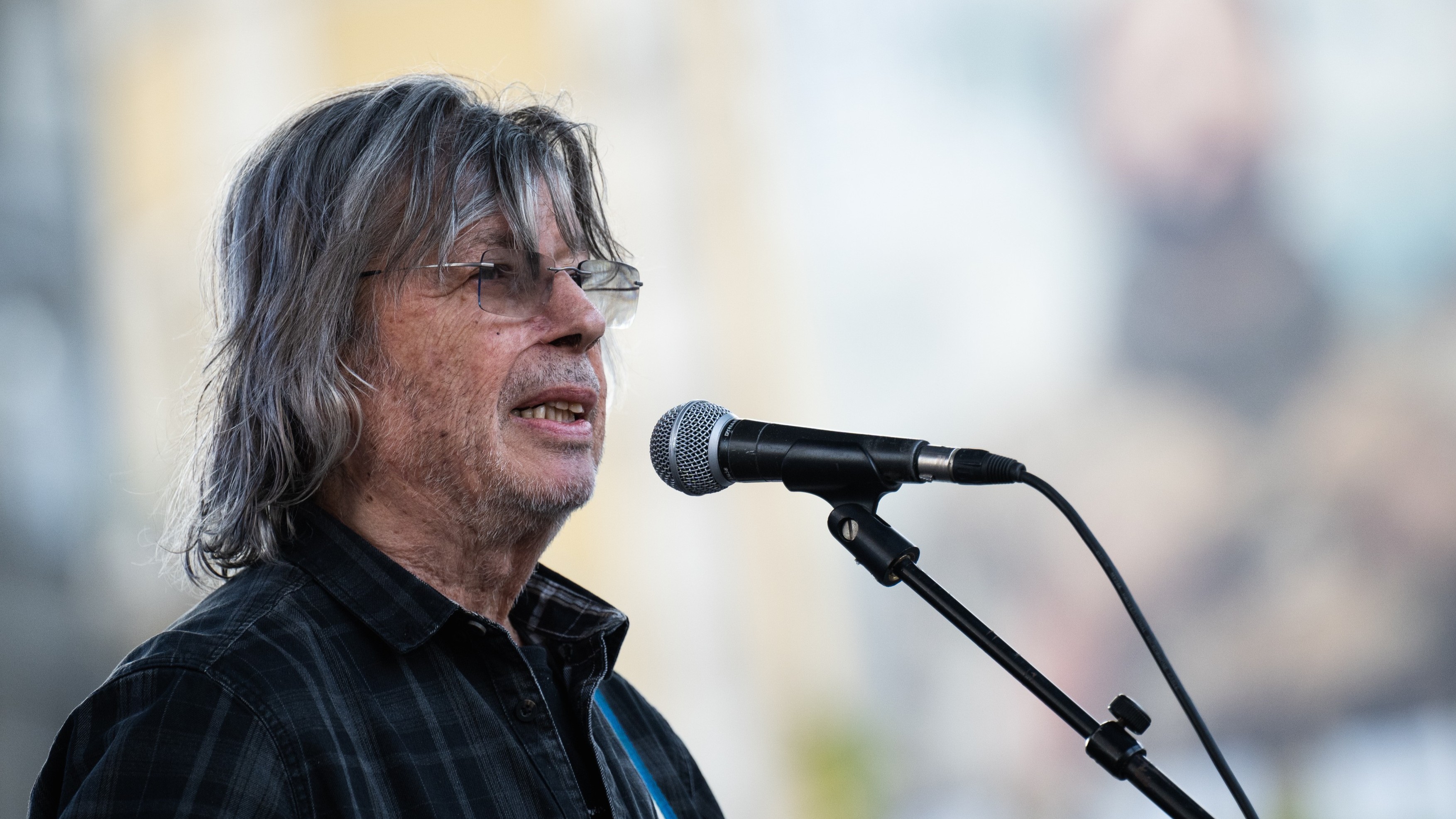 Bródy János a mikrofon előtt áll "Emberek az emberekért" szolidaritási demonstráció színpadán a Blaha Lujza téren