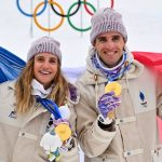 Gold medallists France's Thibault Anselmet (R) and France's Emily Harrop celebrate on the podium after competing in the mixed relay ski mountaineering event during the Milano Cortina 2026 Winter Olympic Games at the Stelvio Ski Centre in Bormio (Valtellina) on February 21, 2026.