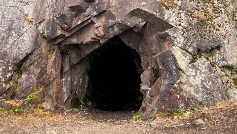 egy sötét barlang bejárata.