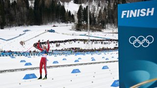 Norway's Johannes Hoesflot Klaebo celebrates as he crosses the finish line to win gold in the men's cross country 50km mass start final event of the Milano Cortina 2026 Winter Olympic Games at Tesero Cross-Country Skiing Stadium in Lago di Tesero (Val di Fiemme) on February 21, 2026.