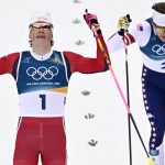 Norway's Johannes Hoesflot Klaebo (L) and USA's Ben Ogden cross the finish line to respectively win gold and silver during the men's cross country sprint classic final event of the Milano Cortina 2026 Winter Olympic Games at Tesero Cross-Country Skiing Stadium in Lago di Tesero (Val di Fiemme), on February 10, 2026.