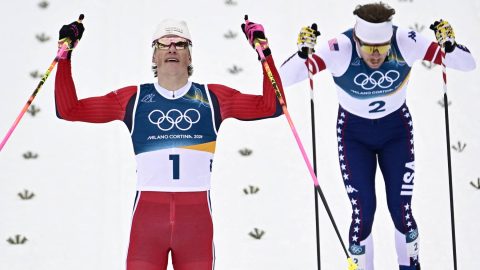 Norway's Johannes Hoesflot Klaebo (L) and USA's Ben Ogden cross the finish line to respectively win gold and silver during the men's cross country sprint classic final event of the Milano Cortina 2026 Winter Olympic Games at Tesero Cross-Country Skiing Stadium in Lago di Tesero (Val di Fiemme), on February 10, 2026.