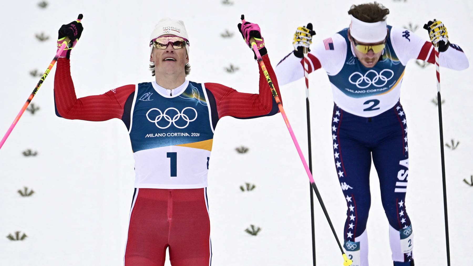 Norway's Johannes Hoesflot Klaebo (L) and USA's Ben Ogden cross the finish line to respectively win gold and silver during the men's cross country sprint classic final event of the Milano Cortina 2026 Winter Olympic Games at Tesero Cross-Country Skiing Stadium in Lago di Tesero (Val di Fiemme), on February 10, 2026.