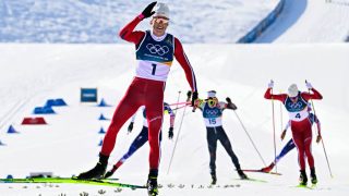 Gold medallist Norway's Johannes Hoesflot Klaebo (L) celebrates after winning during the men's cross country 10km + 10km skiathlon event of the Milano Cortina 2026 Winter Olympic Games at Tesero Cross-Country Skiing Stadium in Lago di Tesero (Val di Fiemme), on February 8, 2026.