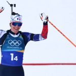 France's Julia Simon celebrates as she crosses the finish line for France to win gold in the mixed biathlon 4 x 6km relay event during the Milano Cortina 2026 Winter Olympic Games at the Anterselva Biathlon Arena (Sudtirol Arena) in Anterselva (Val Pusteria) on February 8, 2026.