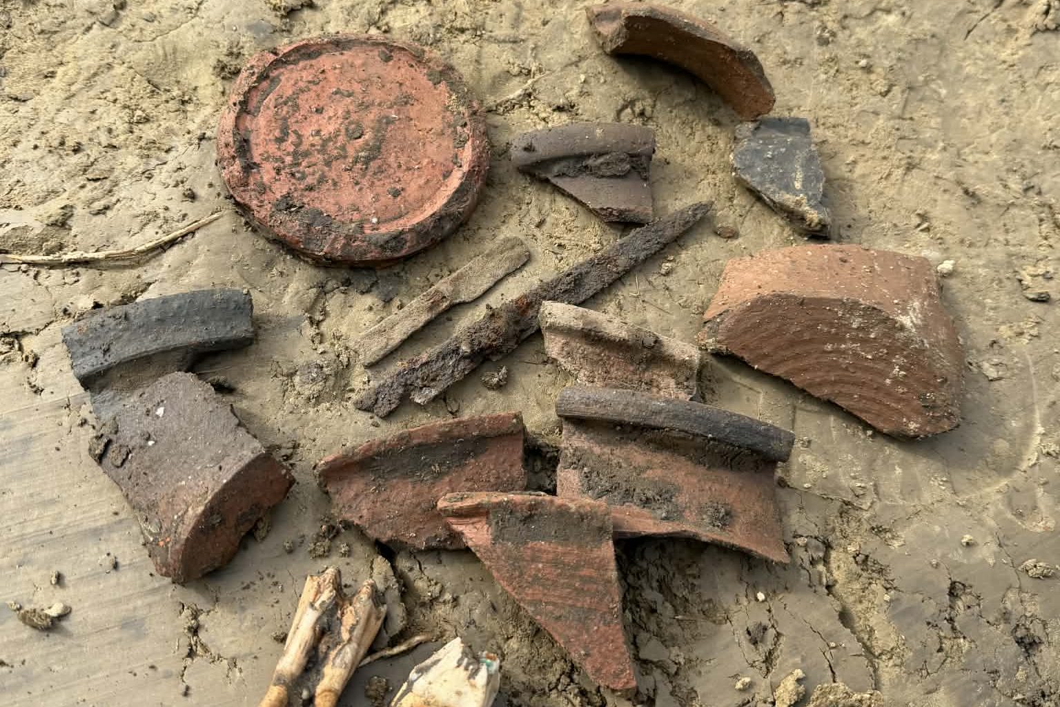 A lelőhelyen felfedezett kerámiatöredékek, kések és állatfogak.