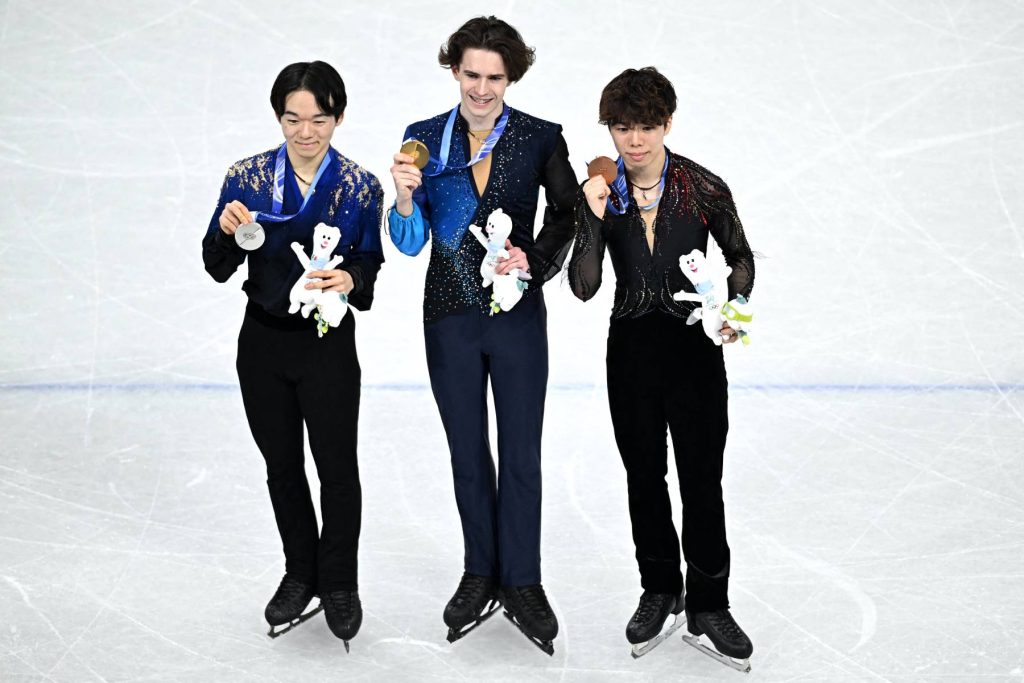Döbbenet: Ilia Malinin kétszer is esett, csak nyolcadik lett a bő két éve veretlen műkorcsolyázó 2 (L-R) Silver medallist Japan's Yuma Kagiyama, gold medallist Kazakhstan's Mikhail Shaidorov and bronze medallist Japan's Shun Sato pose with their medals after the victory ceremony of the figure skating men's singles free skating final during the Milano Cortina 2026 Winter Olympic Games at Milano Ice Skating Arena in Milan on February 13, 2026.