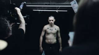 Pogány Induló egy sötét folyosón áll a kamerák előtt a Vajon mit mondana anya? című dokumentumsorozat forgatásán