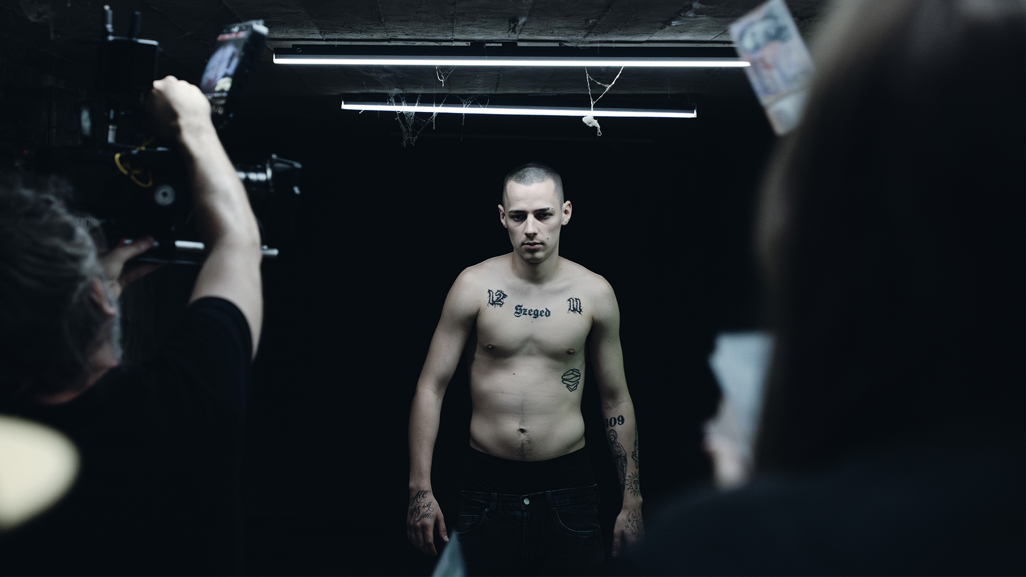 Pogány Induló egy sötét folyosón áll a kamerák előtt a Vajon mit mondana anya? című dokumentumsorozat forgatásán