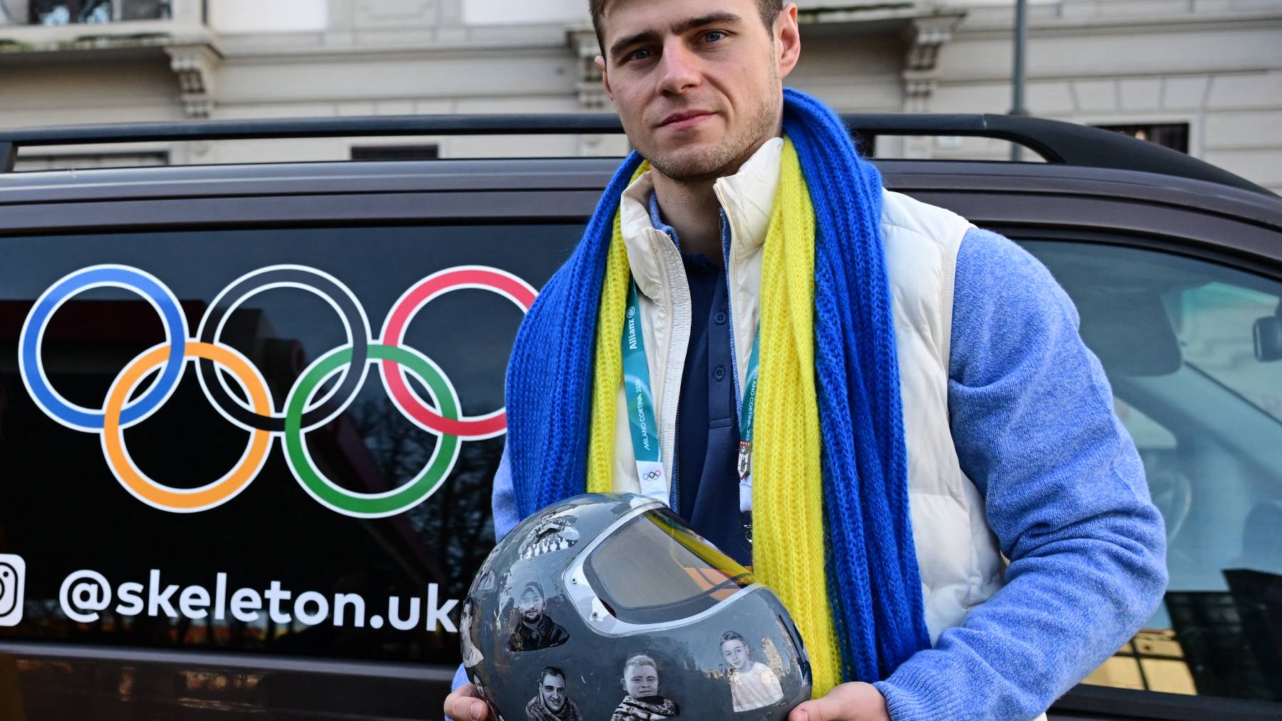 Ukrainian skeleton athlete Vladyslav Heraskevych poses with his helmet after a hearing at the Court of Arbitration for Sport (TAS) in Milan on February 13, 2026. Heraskevych was barred from the Milan-Cortina Games after refusing to back down from wearing a helmet adorned with pictures of Ukrainian sportsmen and women killed since Russian invaded in 2022.