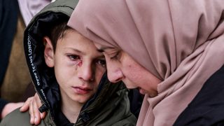 Egy izraeli támadásban megsérült kisfiú a rokonait gyászolja a Ciszjordánia északi részén fekvő Tammun városában, 2026. március 15-én.