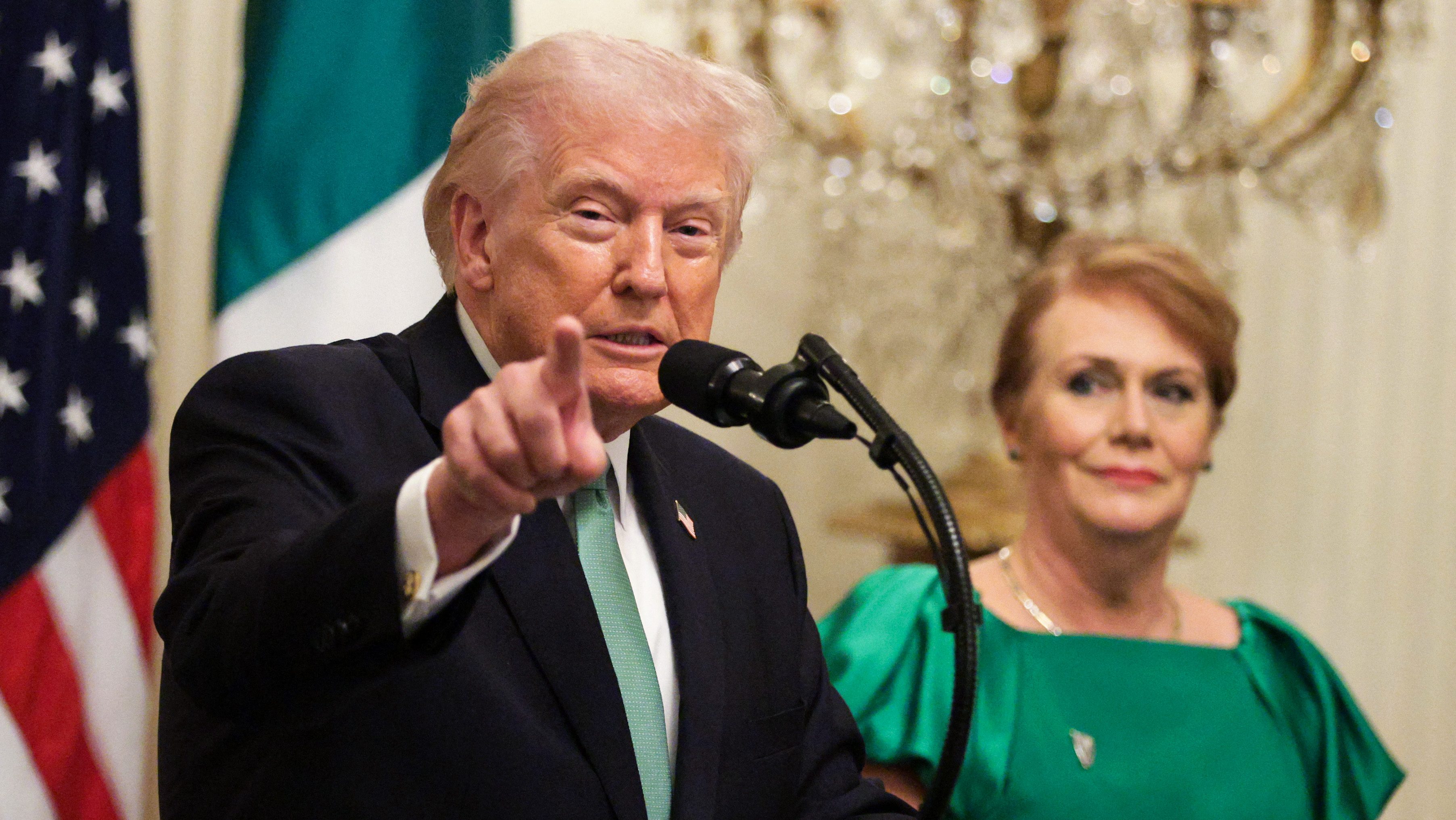 WASHINGTON, DC - MARCH 17: U.S. President Donald Trump speaks alongside Taoiseach of Ireland Micheál Martin's wife Mary O'Shea during a St. Patricks Day event in the East Room of the White House on March 17, 2026 in Washington, DC. The Shamrock Bowl presentation is an annual St. Patrick's Day tradition symbolizing U.S.-Irish relations. Alex Wong/Getty Images/AFP (Photo by ALEX WONG / GETTY IMAGES NORTH AMERICA / Getty Images via AFP)