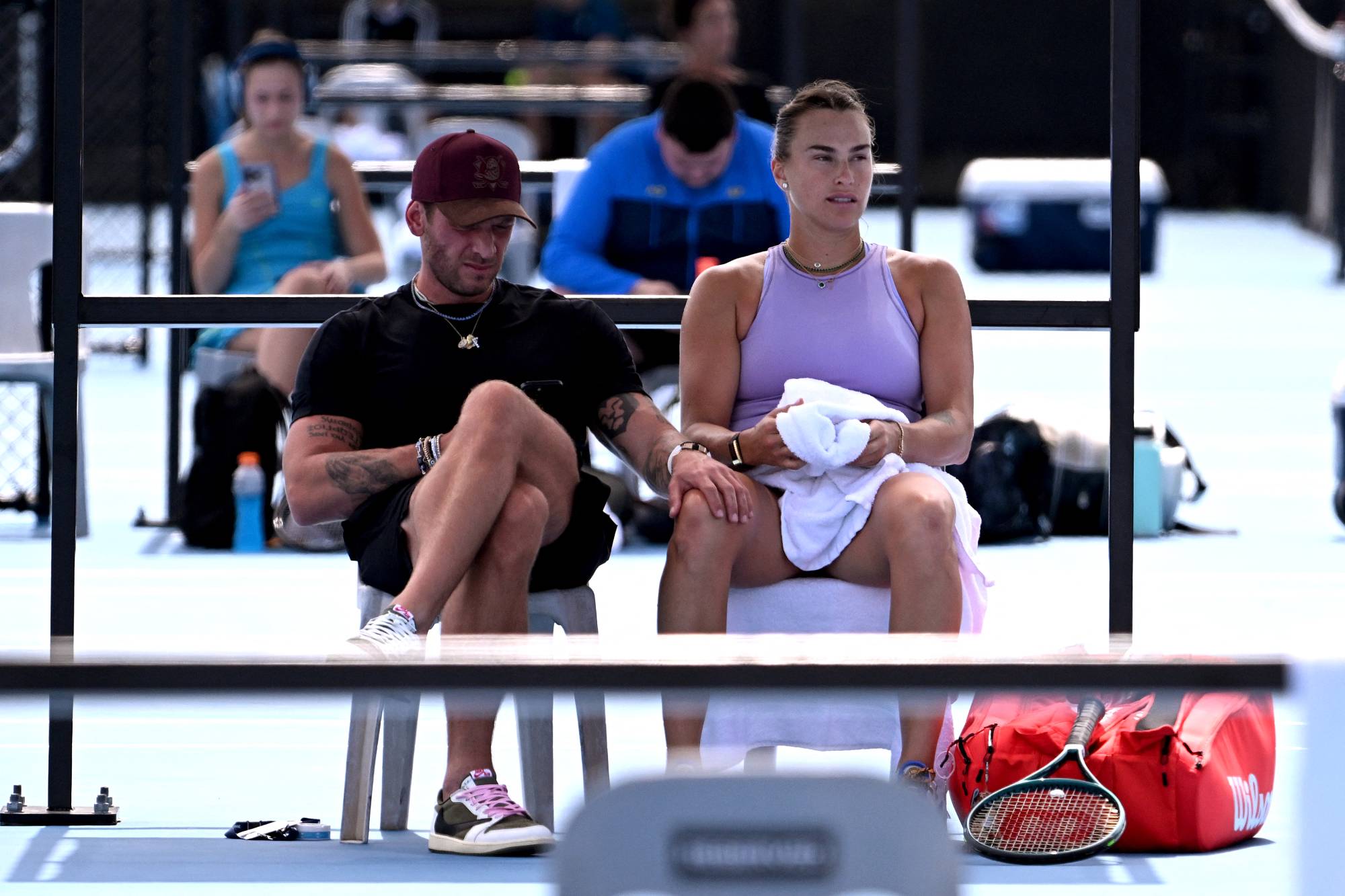 Aryna Sabalenka of Belarus (R) sits with her boyfriend Georgios Frangulis as she trains ahead of her women's singles match at the Brisbane International tennis tournament in Brisbane on December 30, 2024.