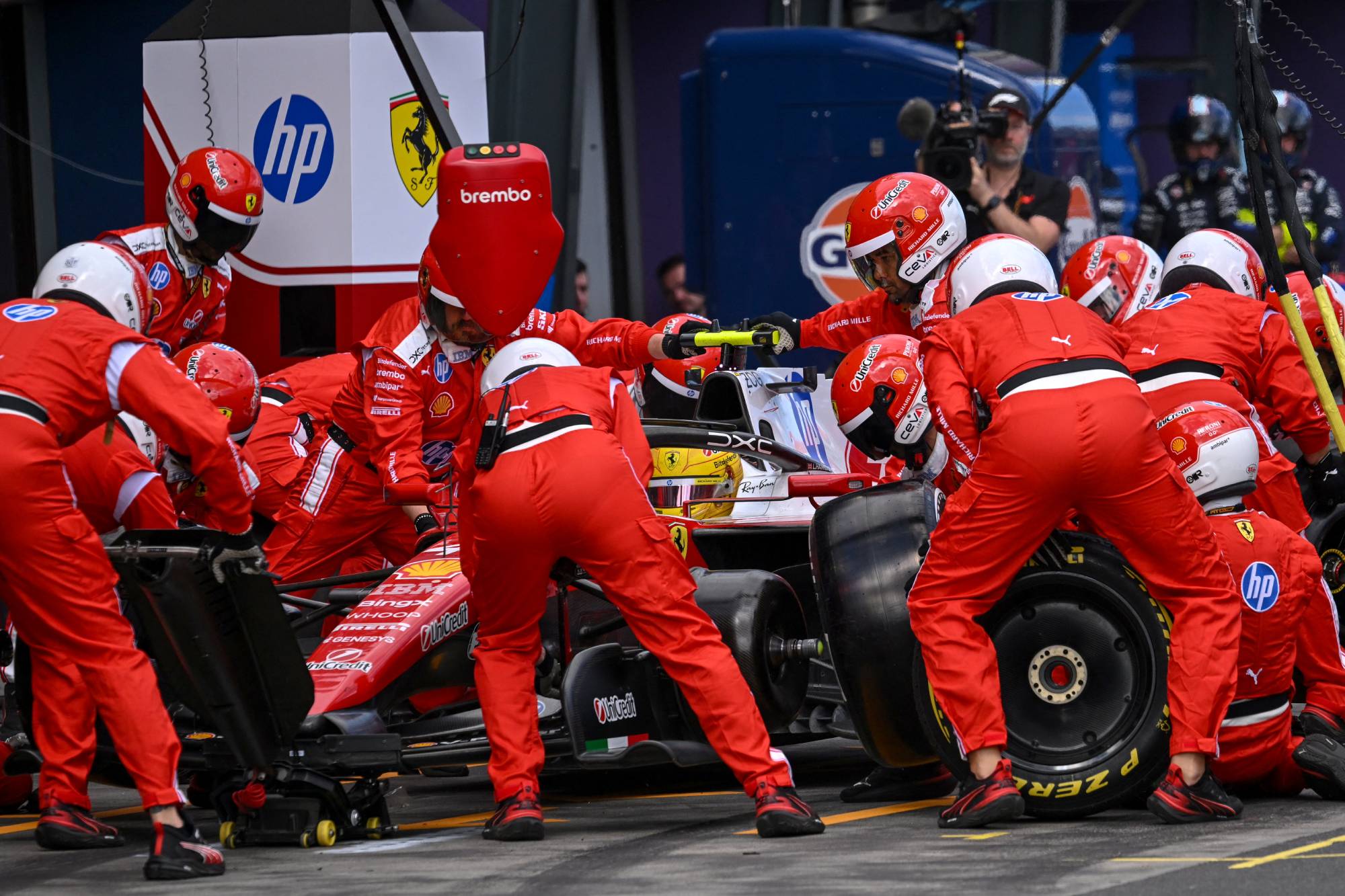 Mechanics work on the car of Ferrari's British driver Lewis Hamilton in the pits during the Formula One Australian Grand Prix at the Albert Park Circuit in Melbourne on March 8, 2026.