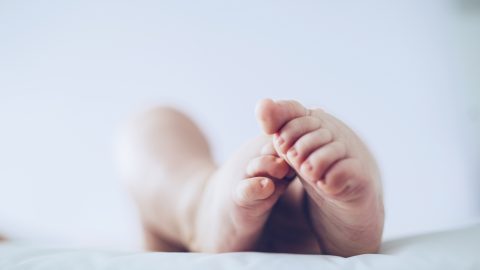 Egy fekvő csecsemő lábai