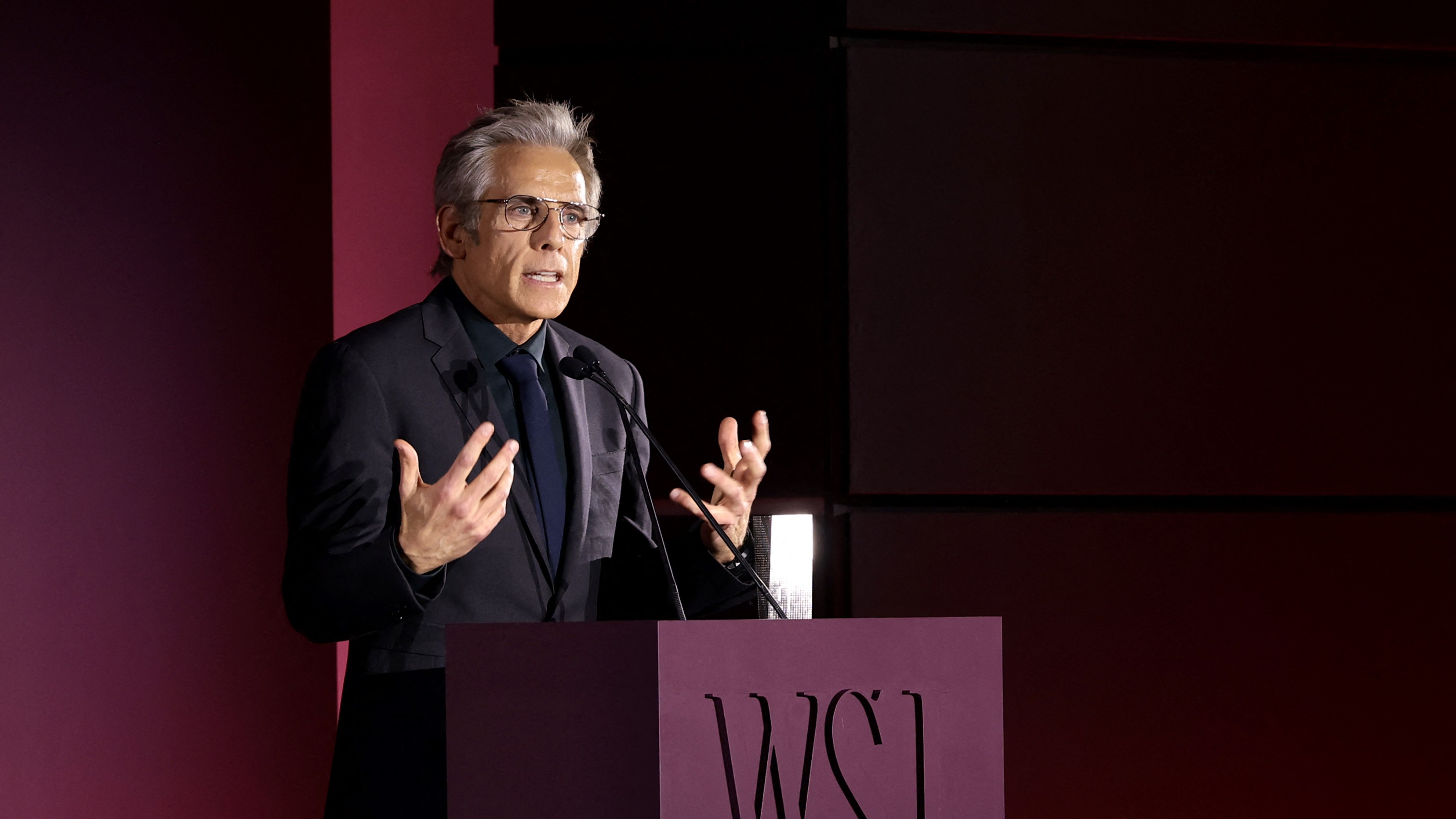 Ben Stiller a WSJ díjátadójának színpadán beszél egy pódium mögött