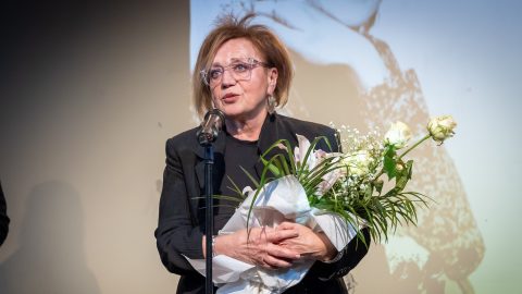 Csákányi Eszter virágcsokorral a kezében beszél a mikrofonba a 2025-ös Psota-díjátadón