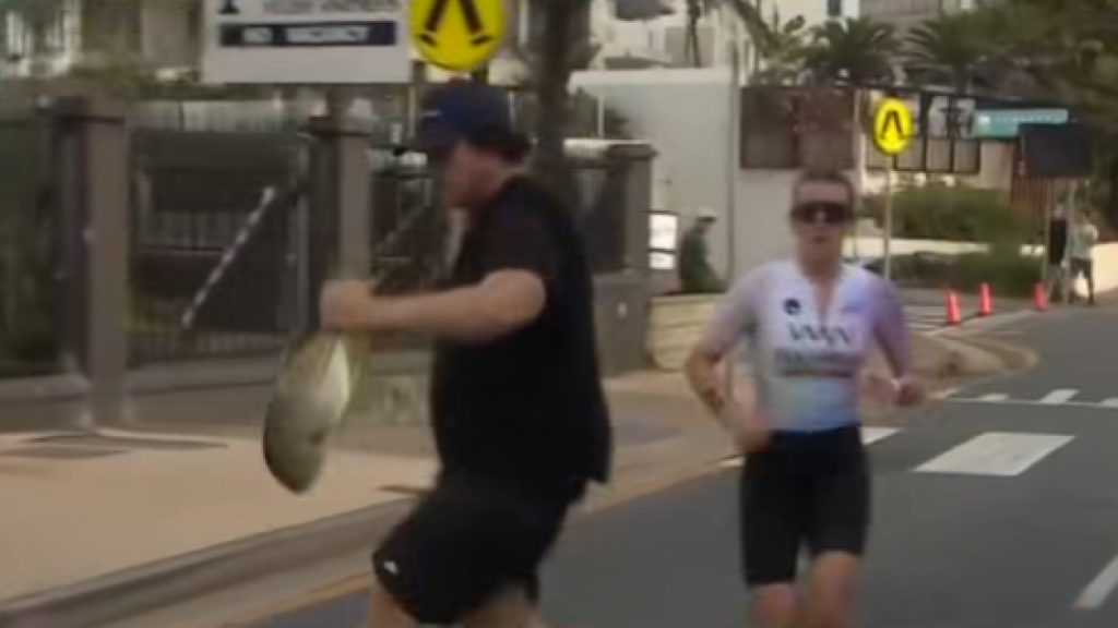 Itt mi történik? Hallal a kezében futott át egy férfi a triatlonversenyző előtt