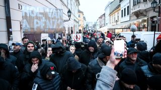 Fekete ruhába öltözött férfiak állták el az Orbán ellen tütetők útját Győrben.