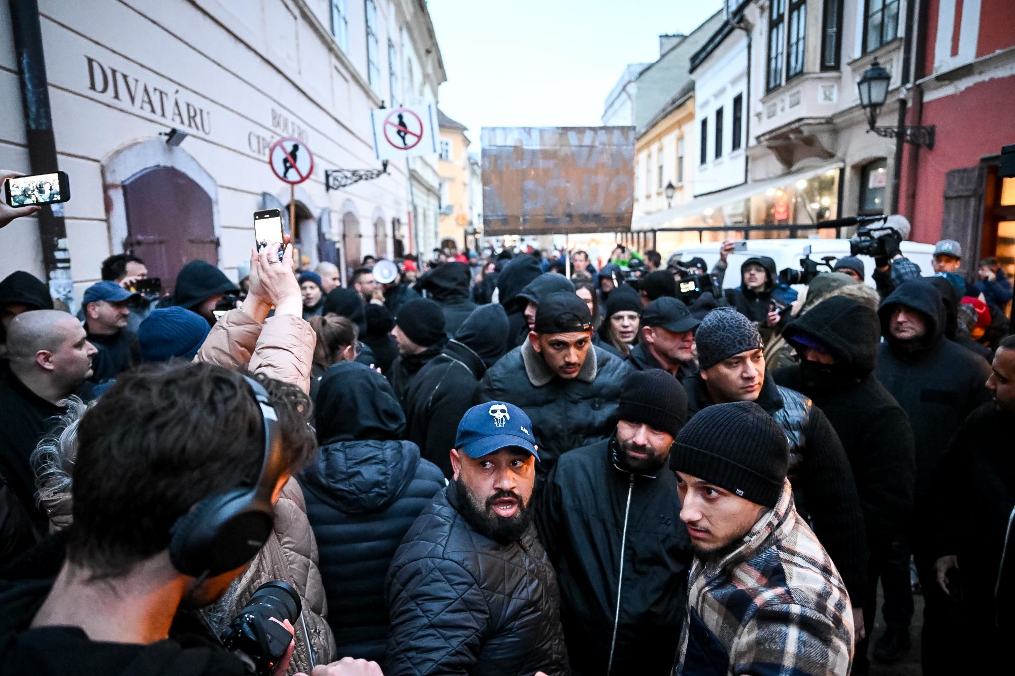 Fekete ruhába öltözött férfiak állták el az Orbán ellen tütetők útját Győrben. 