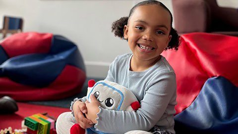 Egy hároméves kislány a Gabbo nevű MI-játékkal.