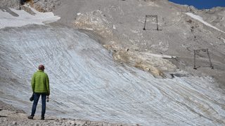 Egy férfi a Nödlichen Schneeferner-gleccsert nézi.