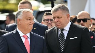 Slovak Prime Minister Robert Fico (R) and Hungarian Prime Minister Viktor Orban react as they attend the ceremony to celebrate the 130th anniversary of the Maria Valeria Bridge that connects the Slovak town of Sturovo with the Hungarian town of Esztergom, near the countries' common border in Esztergom, Hungary on September 28, 2025. The bridge links the two countries across the Danube river. It was opened on September 28, 1895. (Photo by Attila KISBENEDEK / AFP)