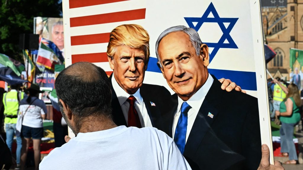 A member of the Iranian community in Australia holds a placard in support of US President Donald Trump and Israeli Prime Minister Benjamin Netanyahu during a rally following US and Israeli attacks on Iran sparking the Middle East war, in Sydney on March 14, 2026. (Photo by Saeed KHAN / AFP)