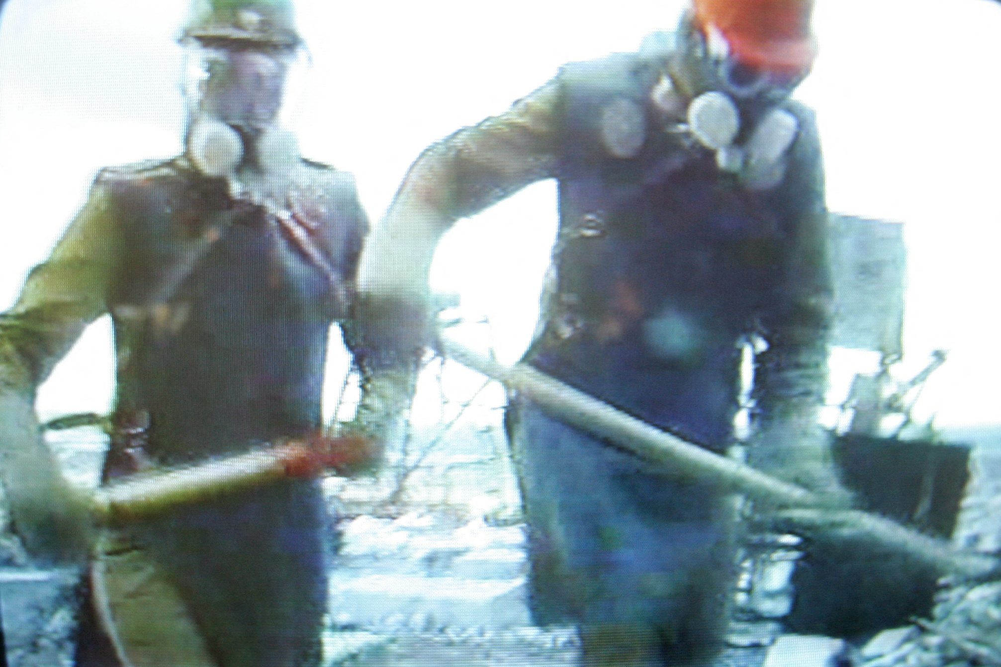 Likvidátorok lapátolják a radioaktív törmeléket a csernobili erőmű tetején.