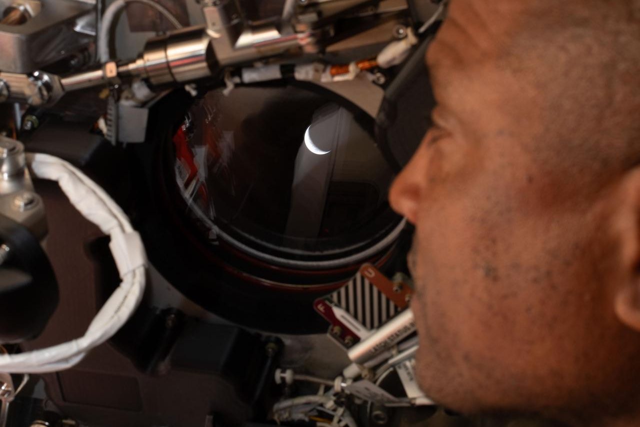 Victor Glover, az Artemis-2 pilótája a Földet nézi az Orion űrkapszula ablakából.