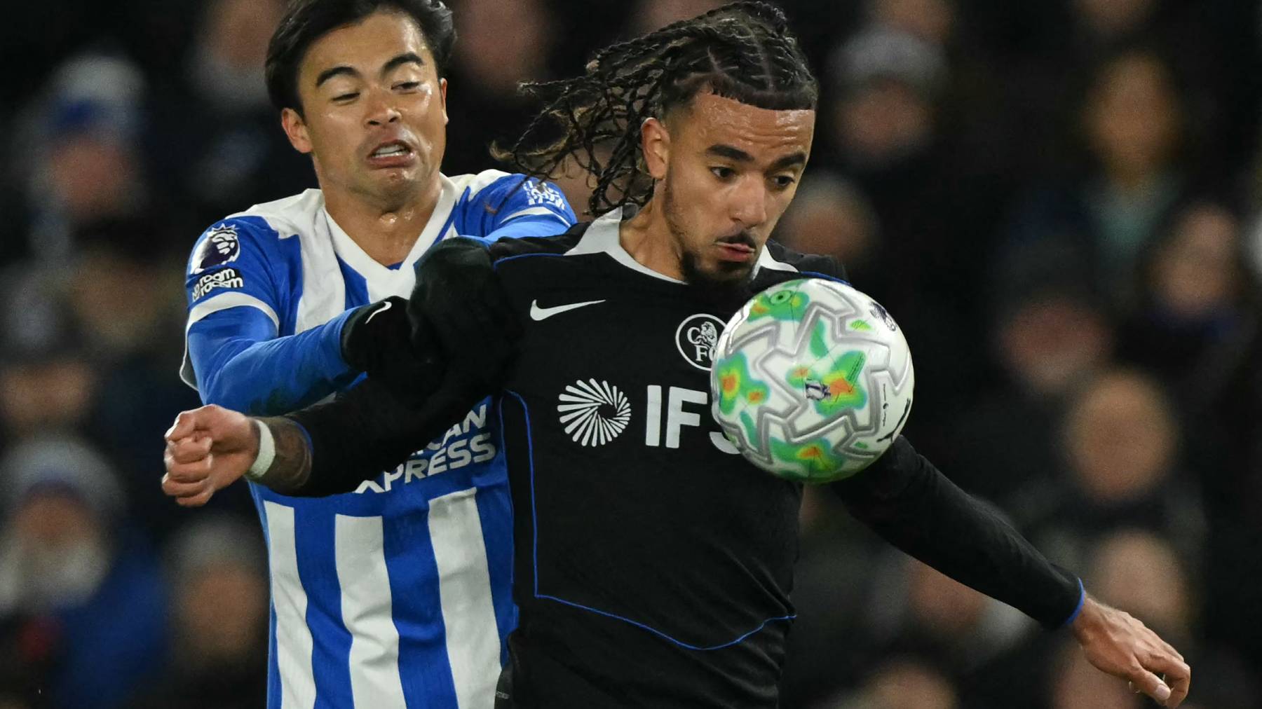 Chelsea's French defender #27 Malo Gusto (R) vies with Brighton's Japanese midfielder #22 Kaoru Mitoma (L) during the English Premier League football match between Brighton and Hove Albion and Chelsea at the American Express Community Stadium in Brighton, southern England on April 21, 2026.