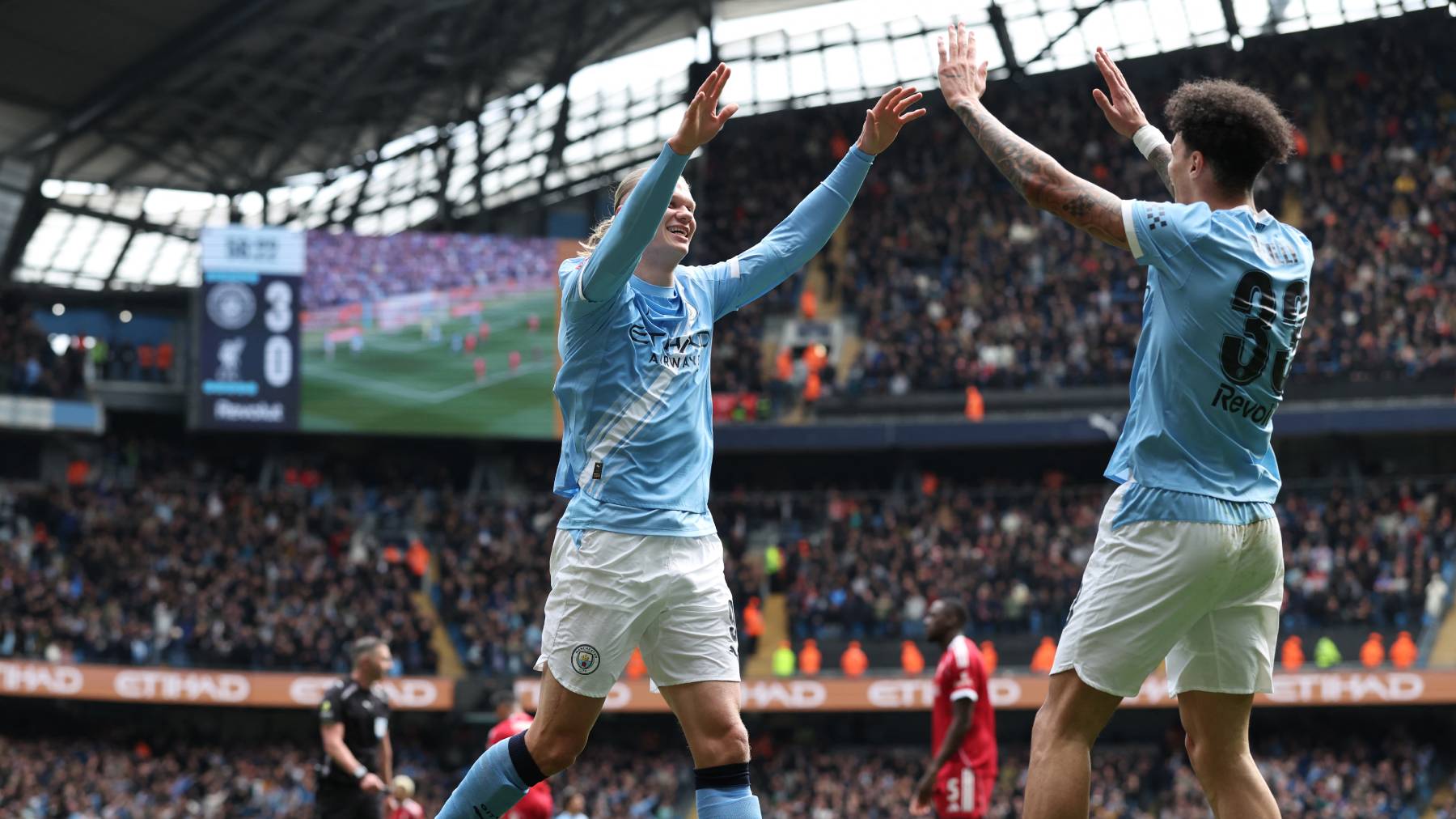 Manchester City's Norwegian striker #09 Erling Haaland (C) celebrates with Manchester City's English midfielder #33 Nico O'Reilly (R) after scoring their fourth goal during the English FA Cup quarter final football match between Manchester City and Liverpool at the Etihad Stadium in Manchester, north west England, on April 4, 2026.