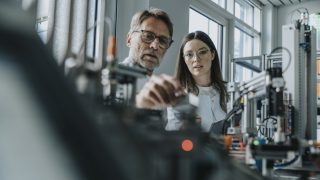 Two scientists in machine engineering lab