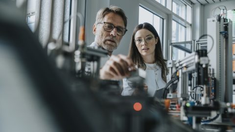Two scientists in machine engineering lab