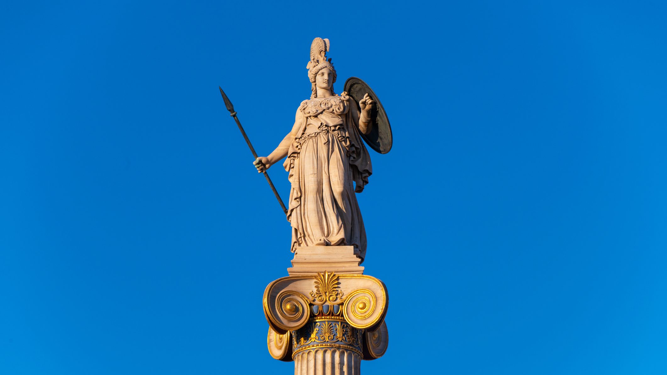 This is a photo of a statue of ancient Greek goddess Athena at sunset. The statue was designed by Greek sculptor Leonidas Drosis as part of the building of the Academy of Sciences in Athens, Greece in 1873.