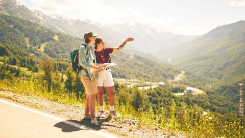 Outdoor exploration of mountainous terrain by two hikers consulting a map, symbolizing adventure.