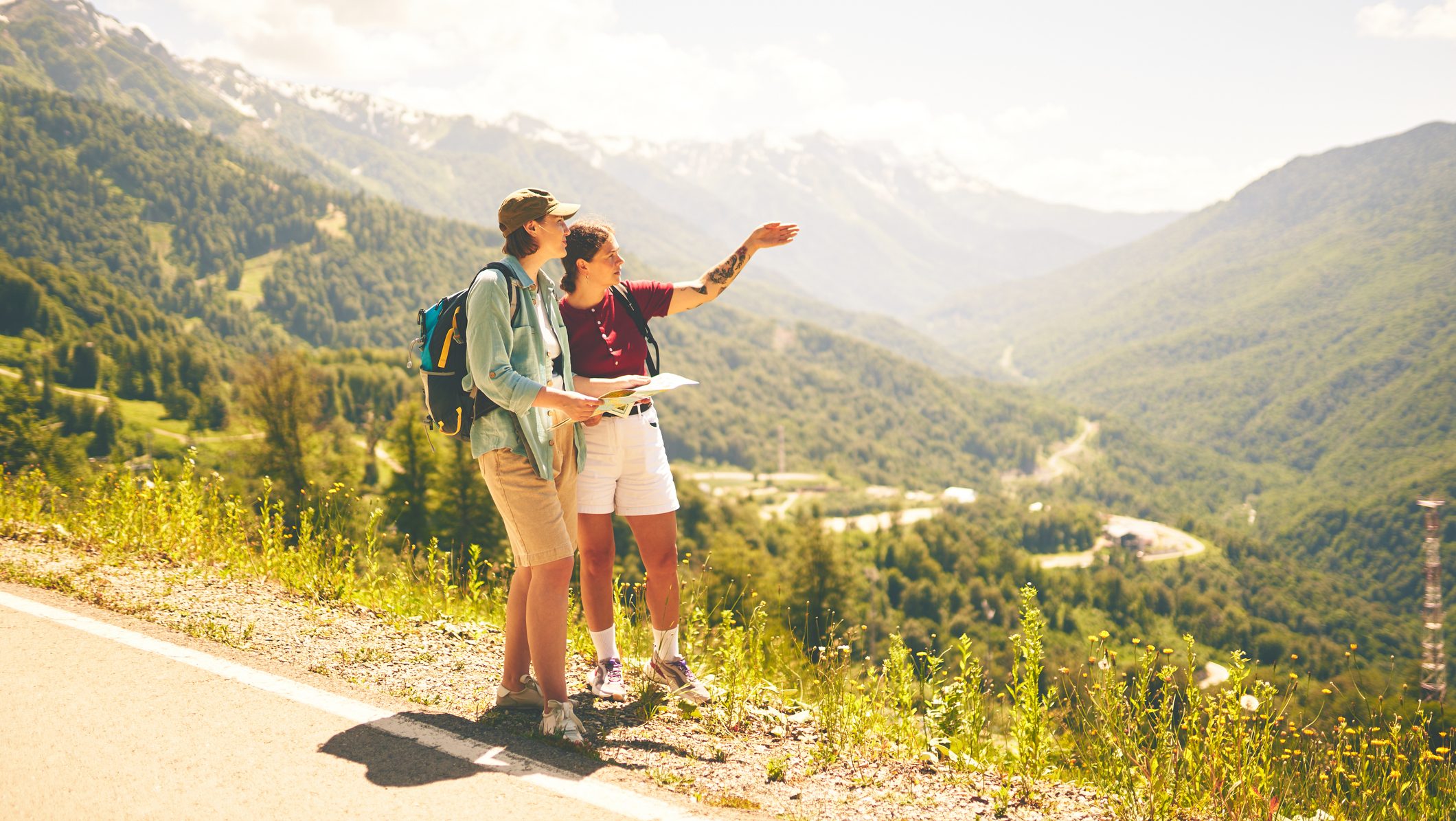 Outdoor exploration of mountainous terrain by two hikers consulting a map, symbolizing adventure.