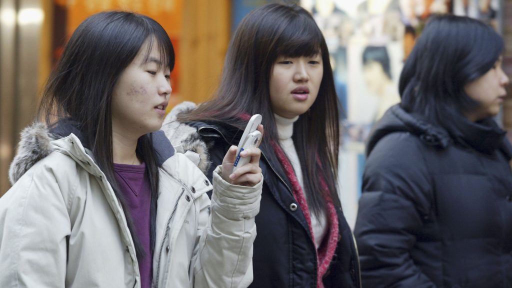 Dél-koreai fiatalok beszélnek telefonon