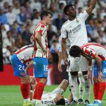 Real Madrid's French forward #10 Kylian Mbappe (C) lies on the pitch with blood on his face after colliding with Girona's Brazilian defender #12 Vitor Reis as Real Madrid's French midfielder #14 Aurelien Tchouameni requests assistance during the Spanish league football match between Real Madrid CF and Girona FC at the Santiago Bernabeu stadium in Madrid on April 10, 2026.